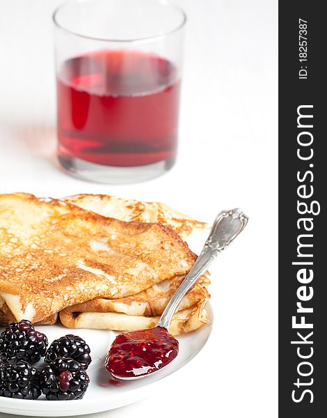 Plate of pancakes with fresh blackberries and glass of juice. Plate of pancakes with fresh blackberries and glass of juice
