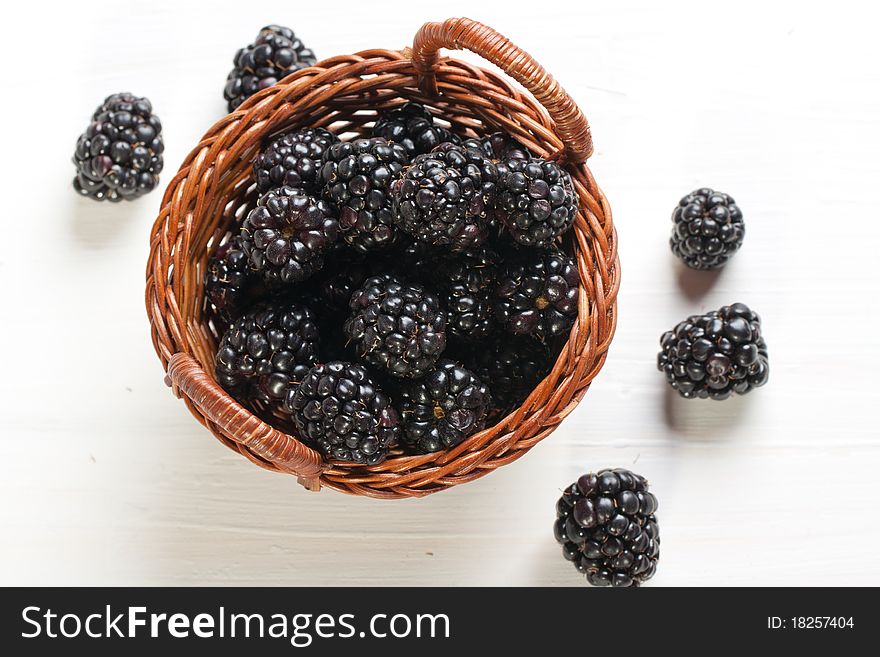 Blackberries in basket on white table