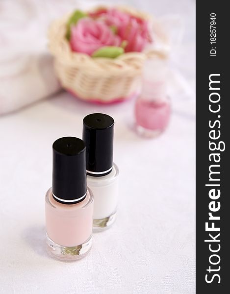 Pink and white enamels for French manicure, soap roses for hands care treatment, vertical