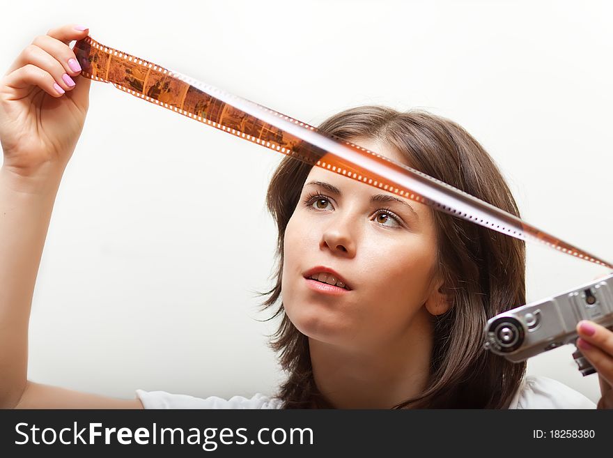 Young woman looking at photofilm tape. on white background