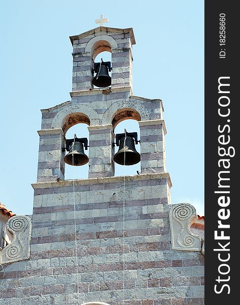 Old stone christian bell tower with three bells on sky background (Montenegro). Old stone christian bell tower with three bells on sky background (Montenegro)