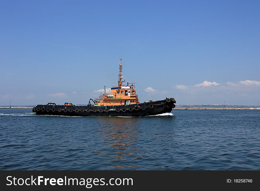 Tugboat underway at speed preparing to guide cruise ship into harbor. Tugboat underway at speed preparing to guide cruise ship into harbor.