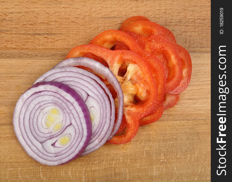 Sliced onion and pepper on a wooden board