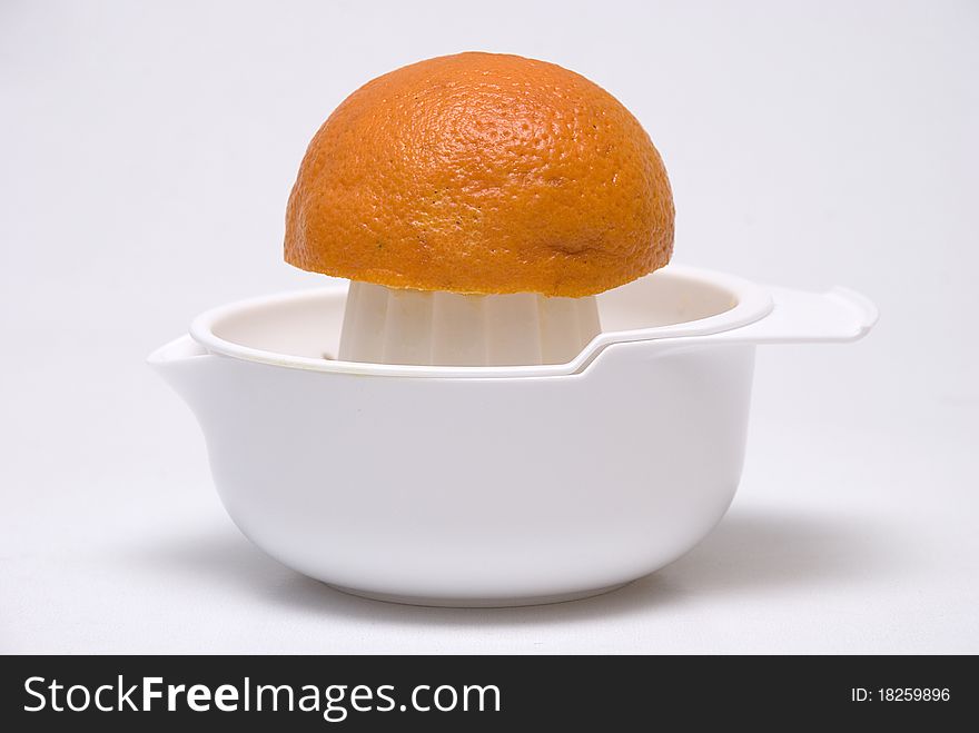 Juice maker with orange on grey background