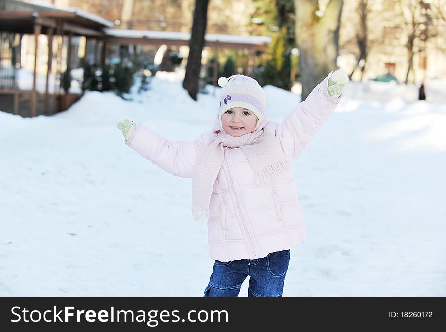 Small beautiful girl playing in park. winter day