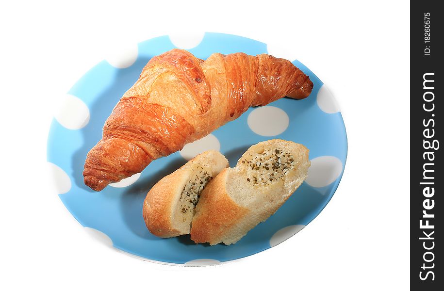Croissant and garlic bread in a plate on white background. Croissant and garlic bread in a plate on white background.