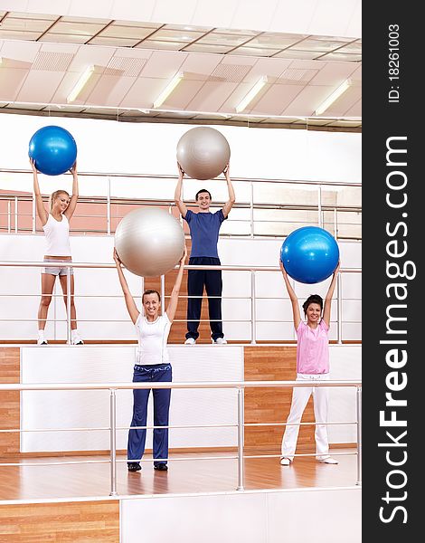 Young people are engaged in aerobic exercise with balls. Young people are engaged in aerobic exercise with balls