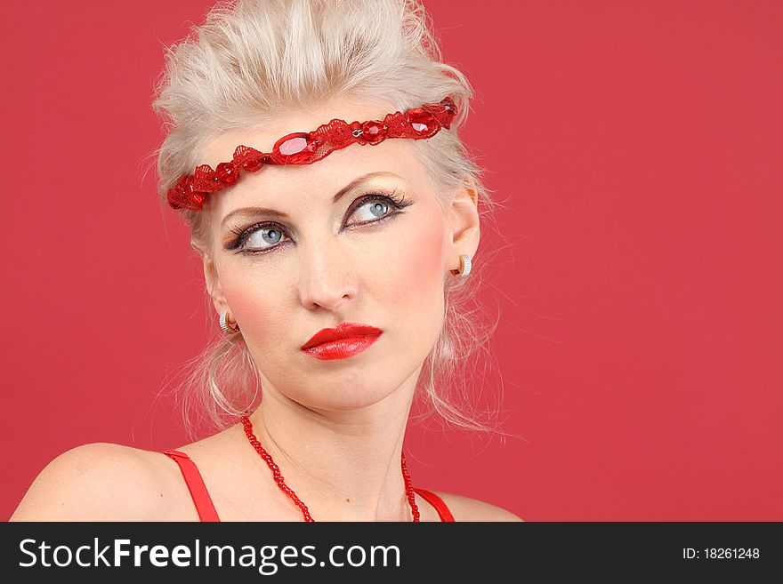 Beautiful female face on red background - close-up