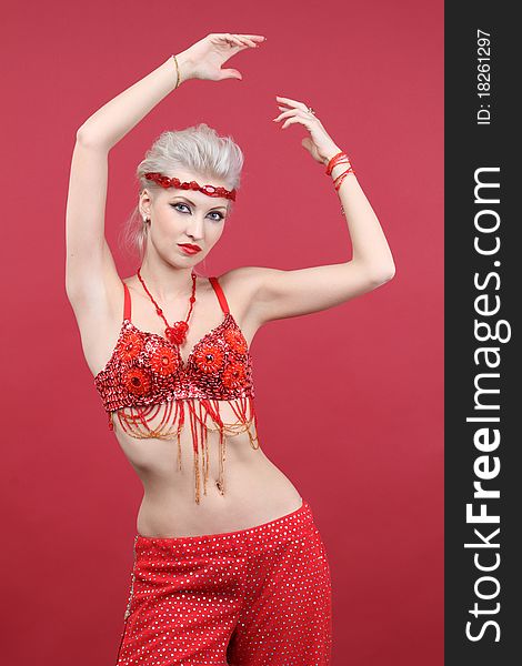 Belly dancer woman dancing on red