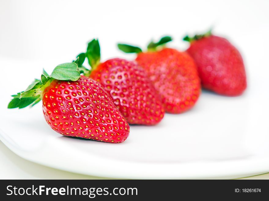 Isolated fruits - Strawberries on white plate.