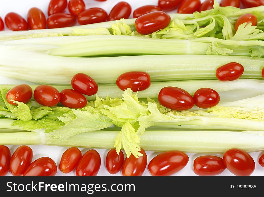 Fresh long green vegetable and small round red fruit mix on white. Fresh long green vegetable and small round red fruit mix on white.