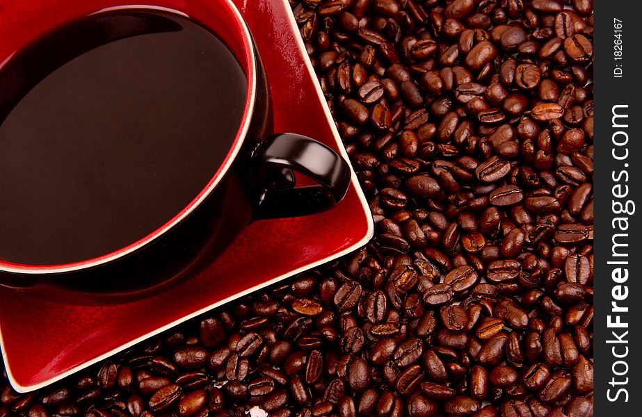 Coffee in cup and saucer with beans on the side. Coffee in cup and saucer with beans on the side