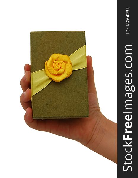 Hand with a small green gift box with gold bow isolated on white background