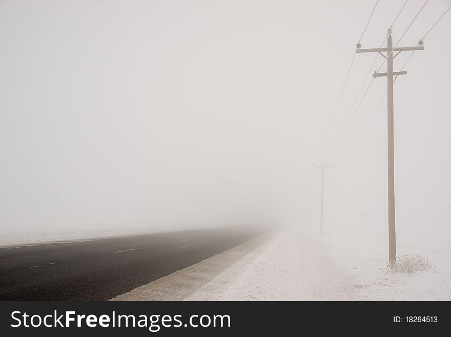 A country road heads into a stormy white out. A country road heads into a stormy white out