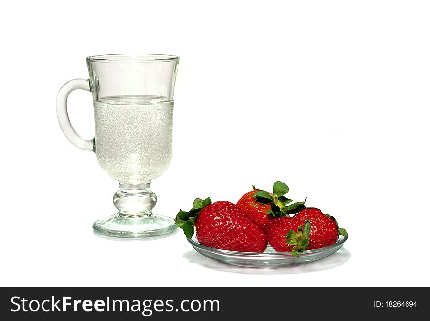 Red berries on a plate and a water glass. Red berries on a plate and a water glass