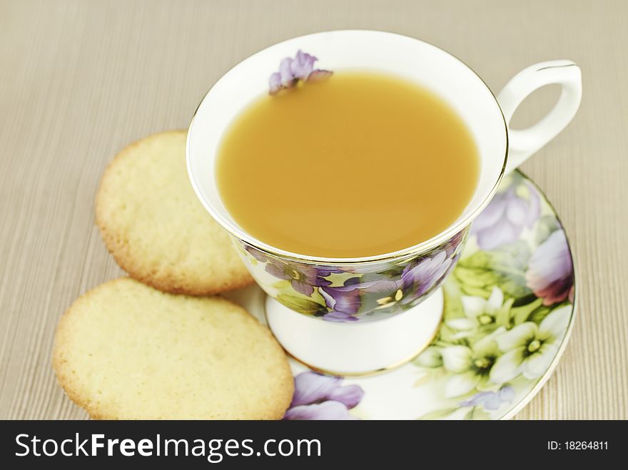 A china cup filled with Wassail, a hot spiced fruit punch, with homemade sugar cookies, selective focus on top of cup, top view. A china cup filled with Wassail, a hot spiced fruit punch, with homemade sugar cookies, selective focus on top of cup, top view