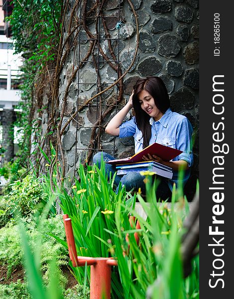 A female student is studying with her laptop in university's park. A female student is studying with her laptop in university's park