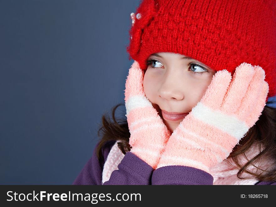 Girl in winter clothes on blue background