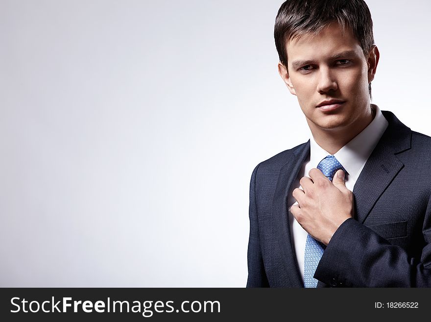 Attractive businessman in a business suit with a gray background