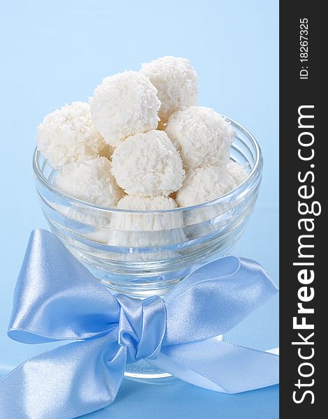Homemade coconut candies in a bowl with a bow