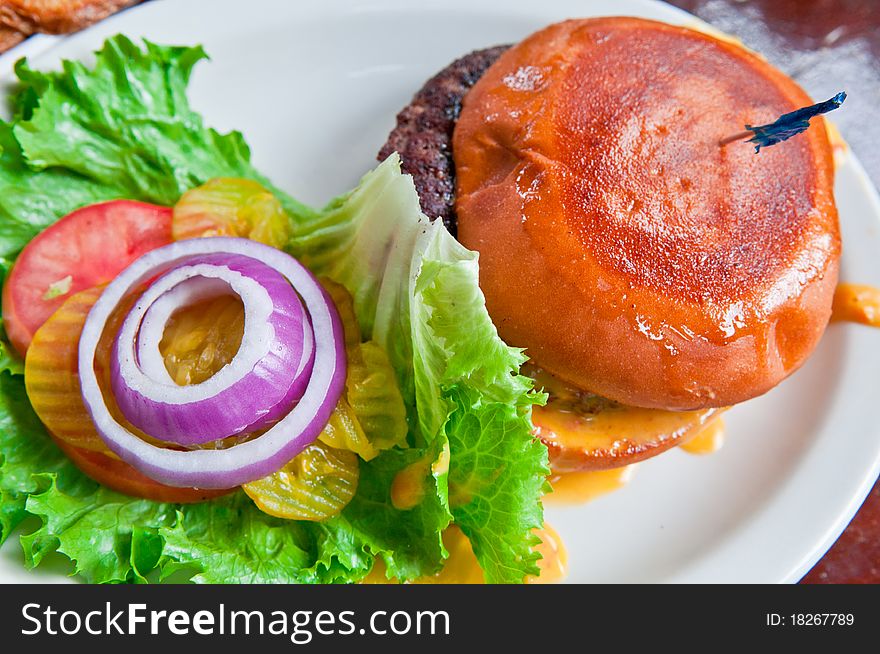 A juicy cheeseburger with all of the trimmings ready to eat