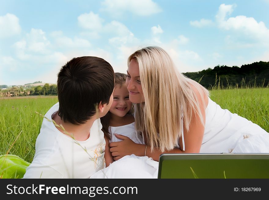 Happy family enjoy outdoors with computer