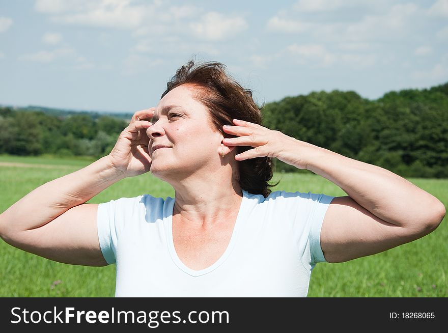 Happy elderly woman on the meadow