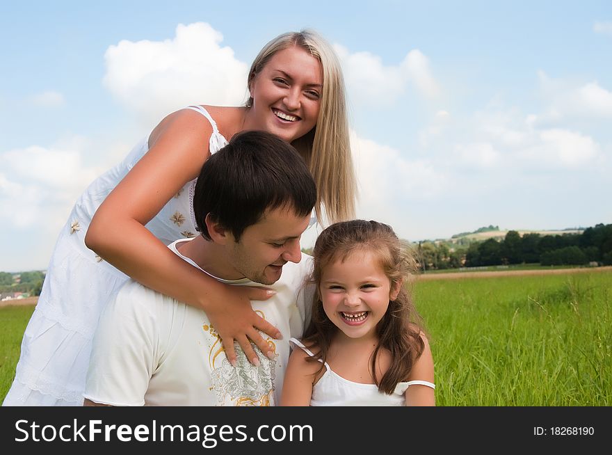 Happy young family enjoy on the meadow. Happy young family enjoy on the meadow