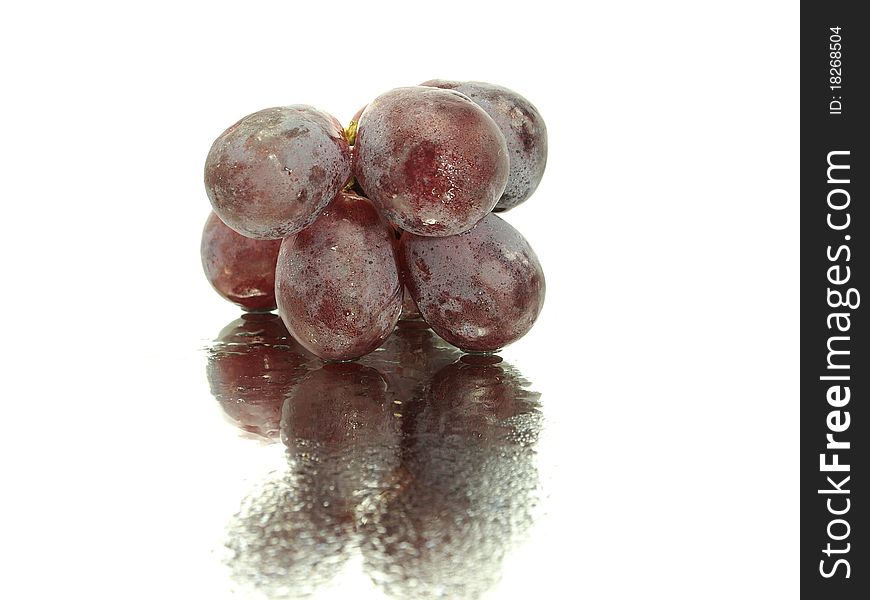 Red grape on a white background with water drops