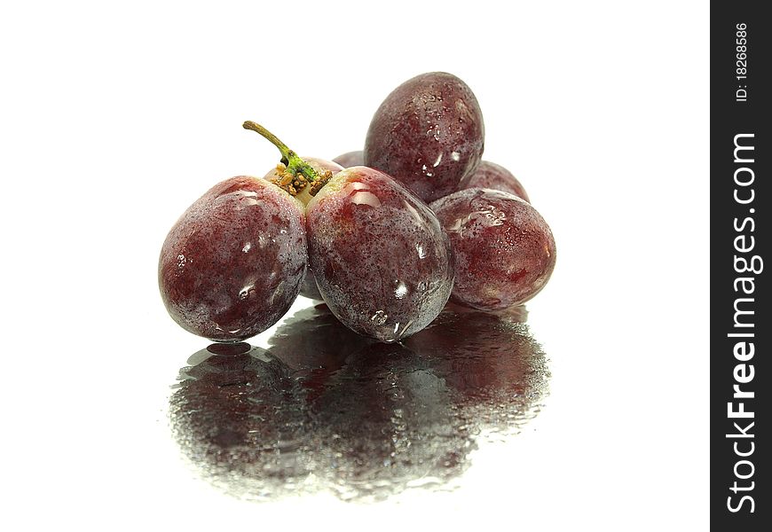 Red grape on a white background with water drops