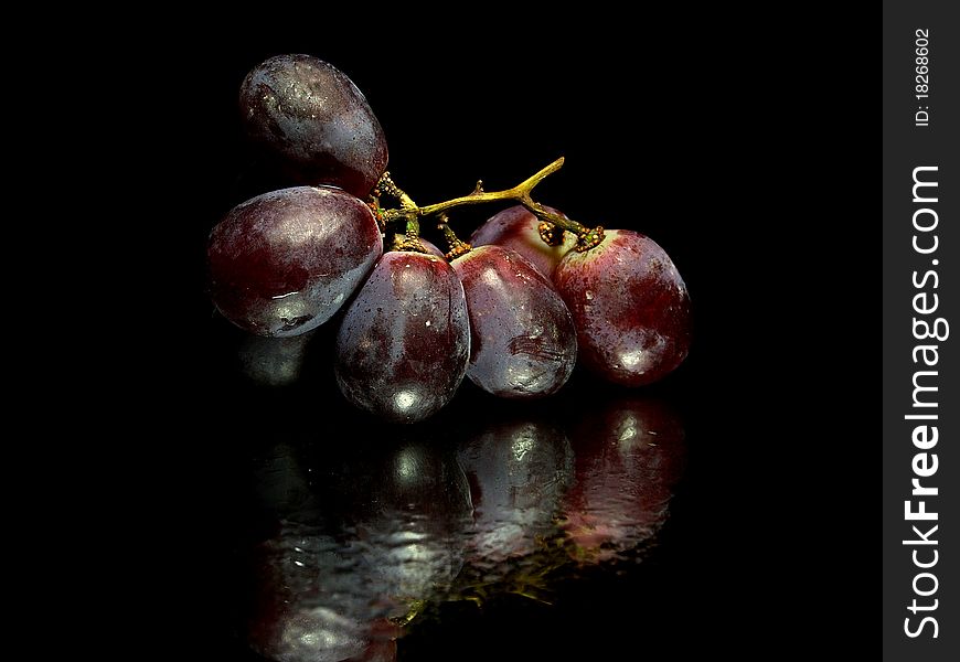 Red grape on a white background with water drops