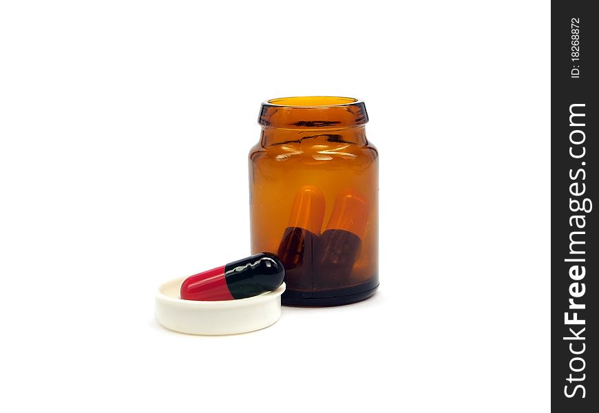 Pharmaceutical capsules in glass bottle on a white background