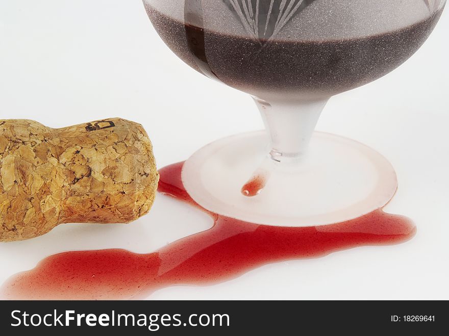 Poured out red wine, glass and winy cork