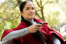 Woman With A Cell Phone, Sitting In A Park Stock Photo
