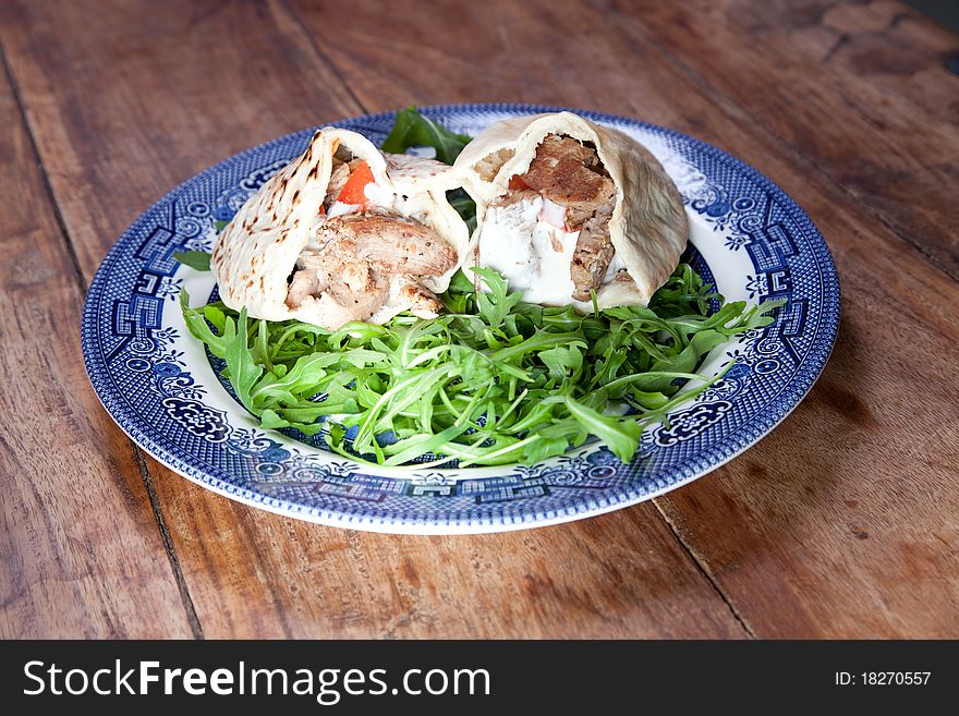 Pita bread sandwiches in blue plate on wooden table