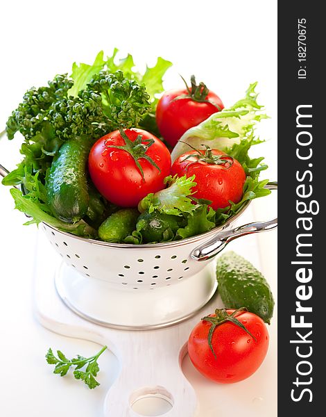 Tomatoes,cucumbers and lettuce leaves in a colander. Tomatoes,cucumbers and lettuce leaves in a colander