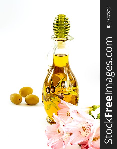 Fresh olive oil in a glass bottle on a white background