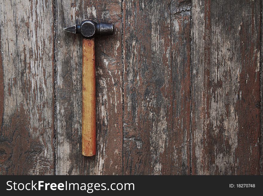 Old hammer against wooden wall. Old hammer against wooden wall