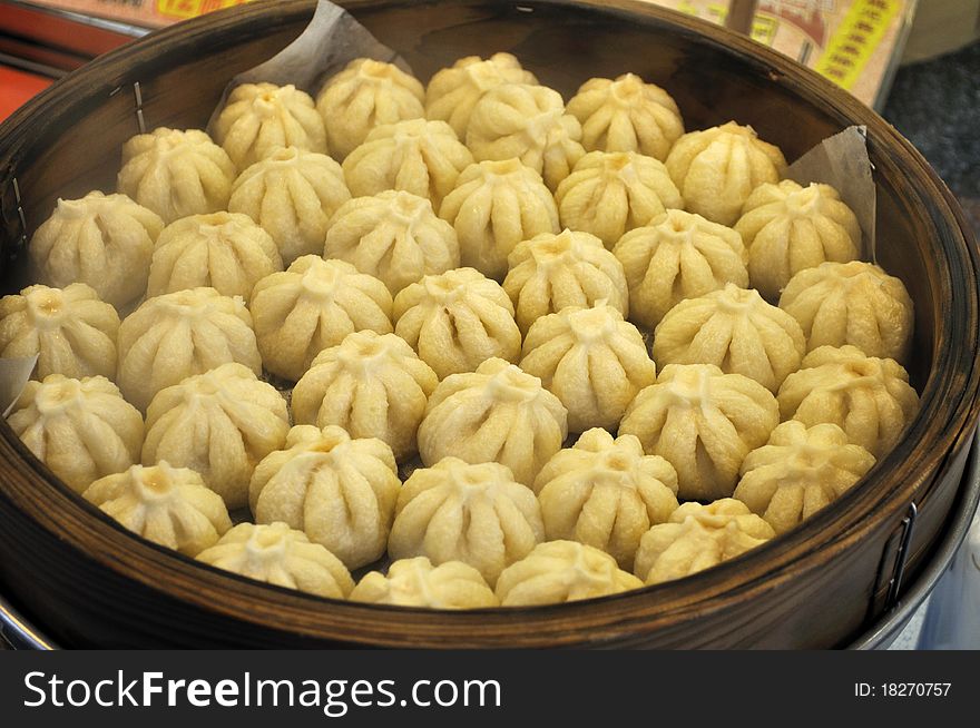 A large bamboo steamer filled with small pork buns (manju) shaped like little flowers. Japanese food. A large bamboo steamer filled with small pork buns (manju) shaped like little flowers. Japanese food.