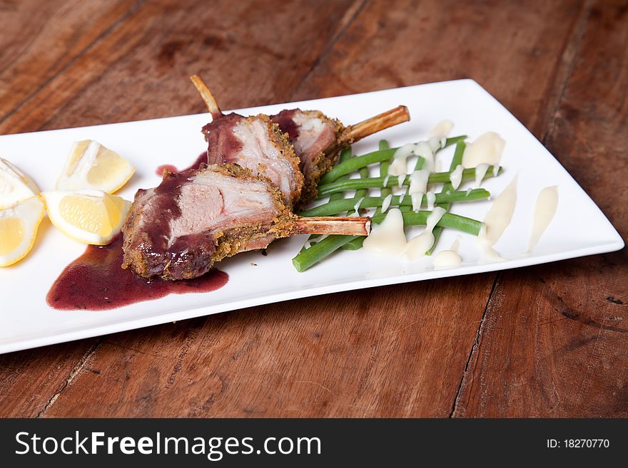 Rack of lamb with vegetables on wooden table