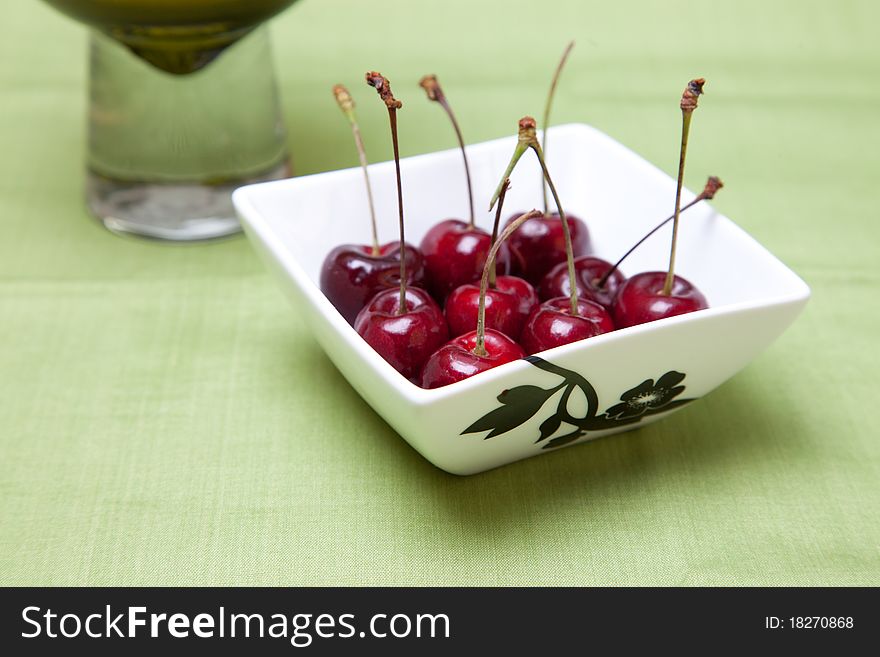 Cherries in bowl in Green background