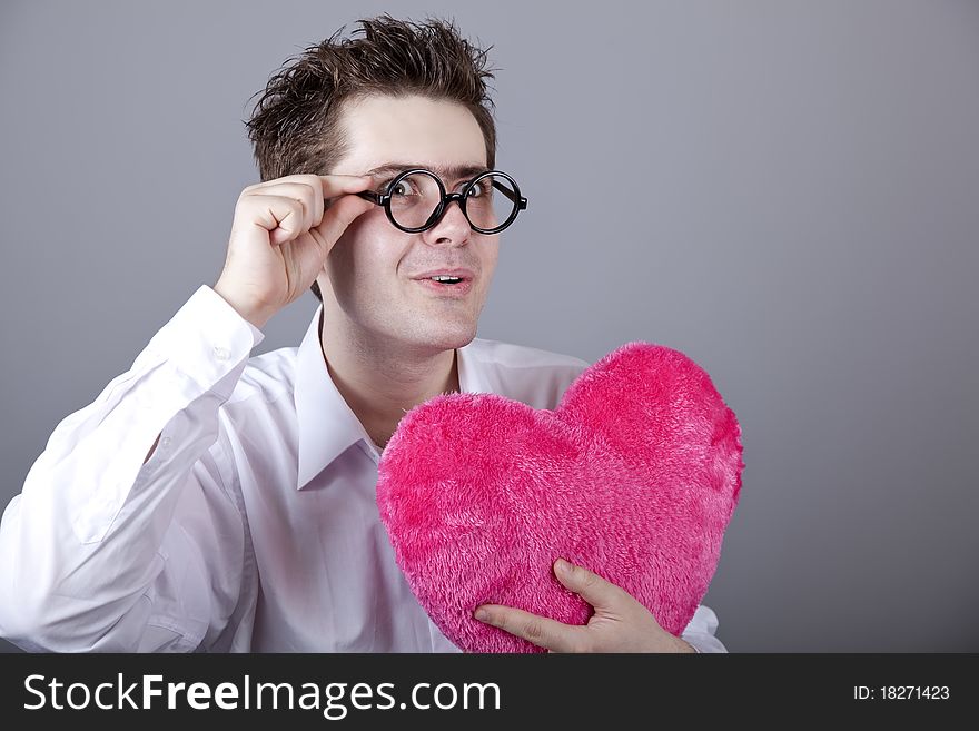 Funny men with toy heart. Studio shot.