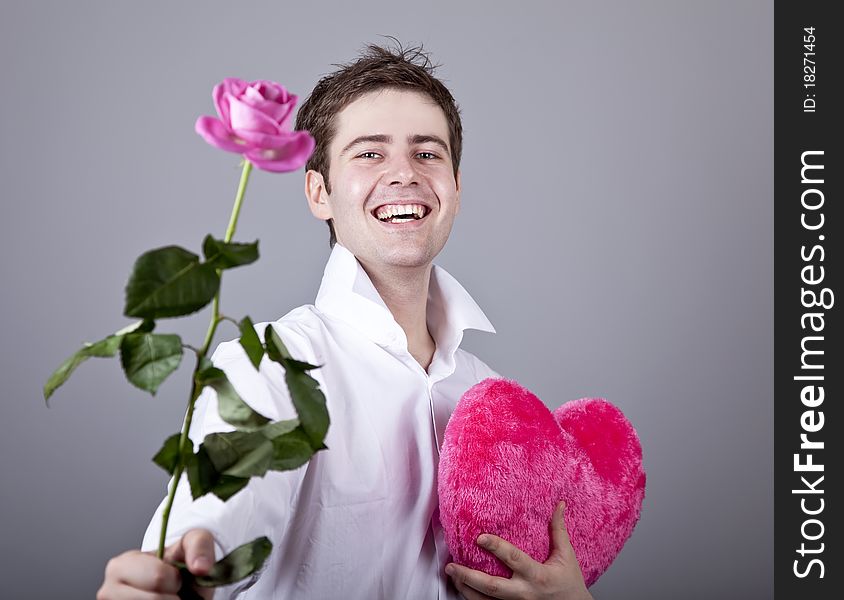 Funny men with rose and toy heart. Studio shot.