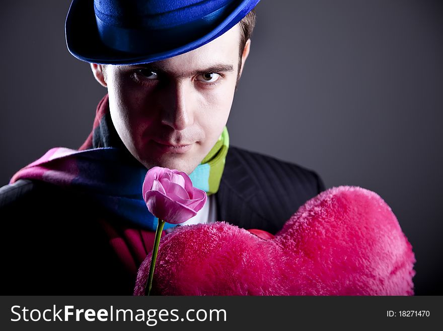 Mysterious men with toy and rose. Studio shot.