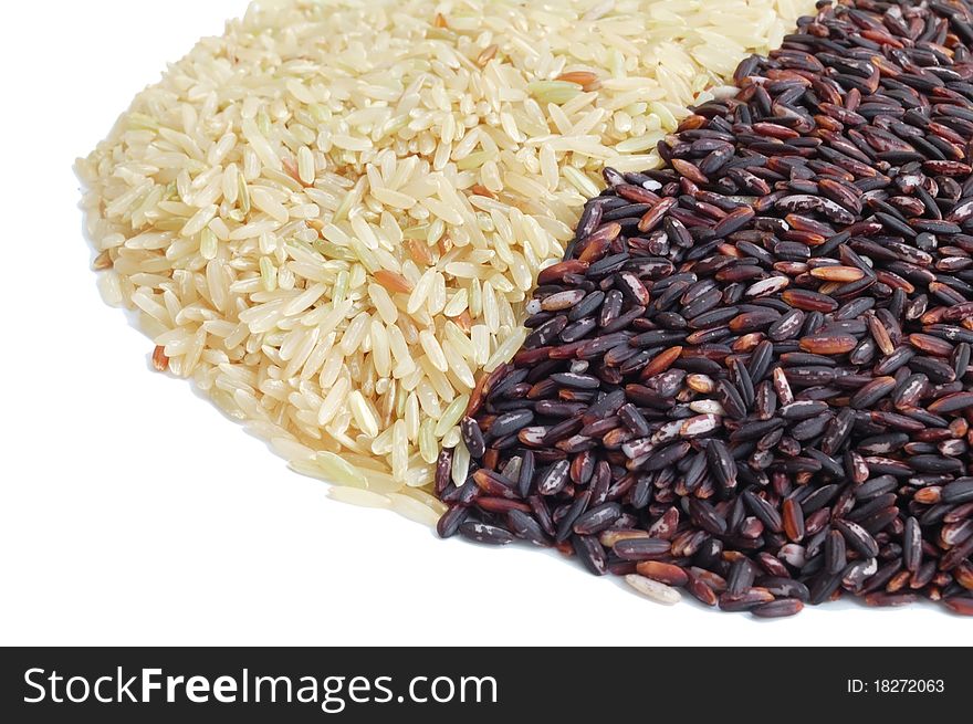 Isolated brown and black indica rice on white background, side view. Isolated brown and black indica rice on white background, side view