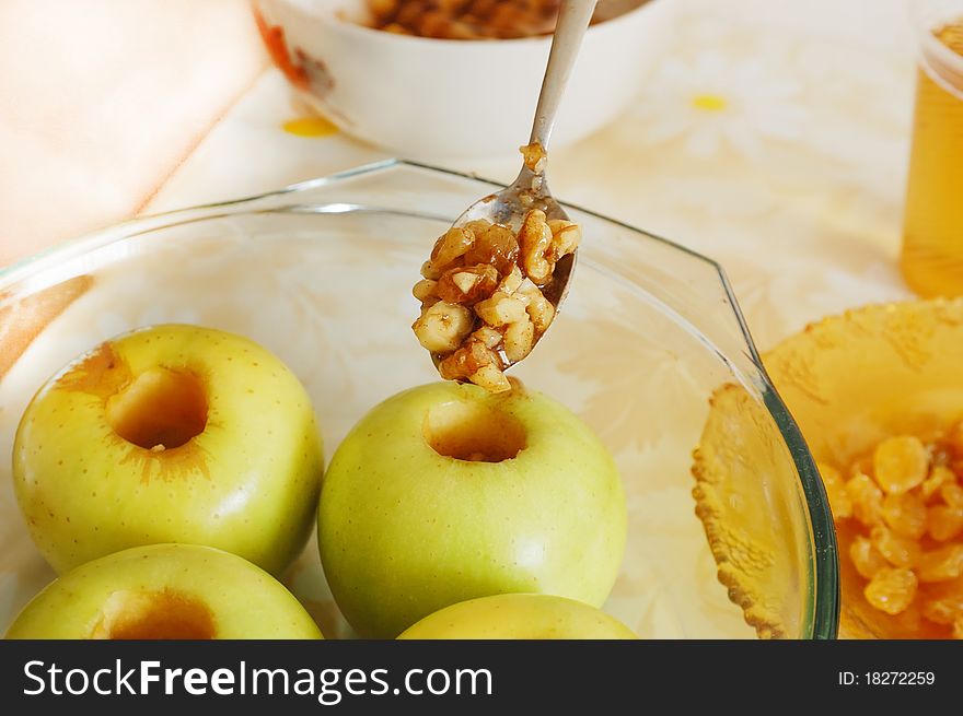 Filling an apple with nuts, raisins and cinnamon