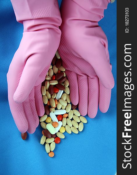 Hands with pills and pink gloves. Hands with pills and pink gloves