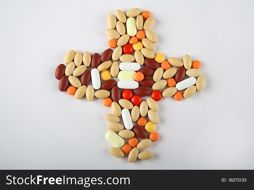 Pills forming a medical cross shape. Pills forming a medical cross shape