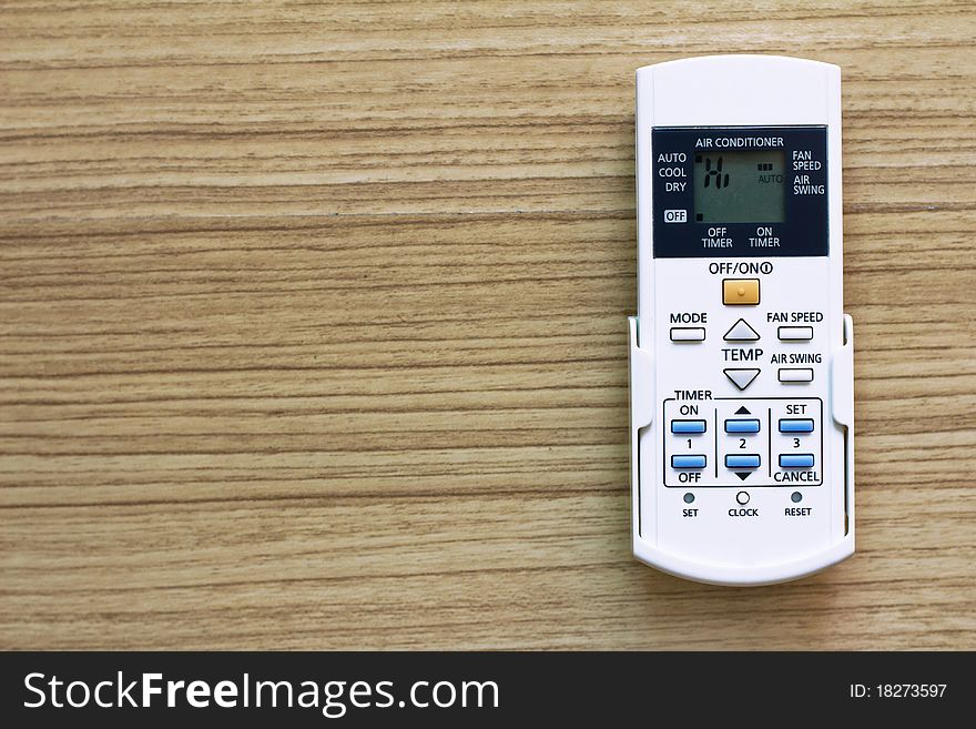 Air Conditioner remote control on wood background