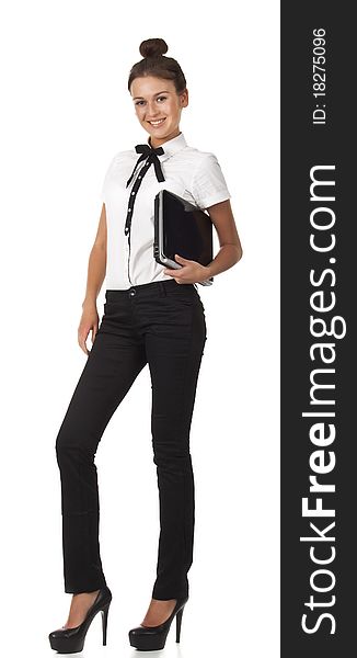 Girl in office attire stands and holds a laptop co